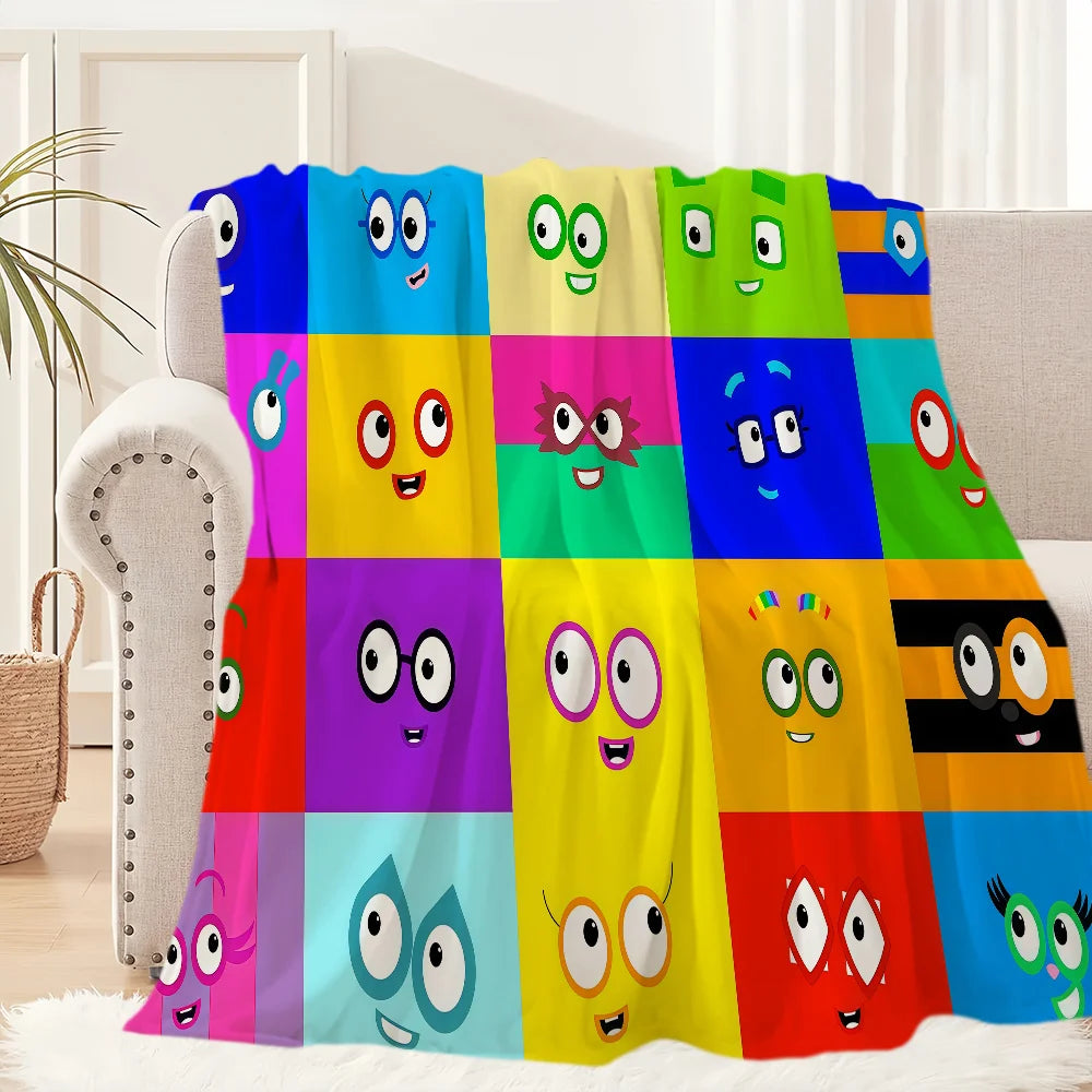 A colorful set of cartoon-themed throw blankets displayed on a sofa.