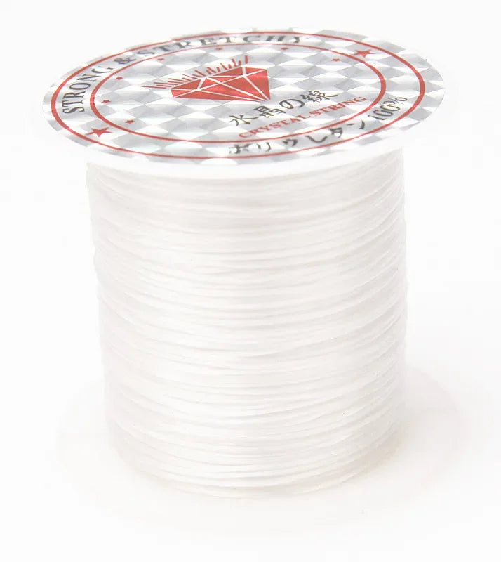 A spool of multicolor elastic beading cord with a circular label featuring the text STRONG & STRETCH and CRYSTAL STRING