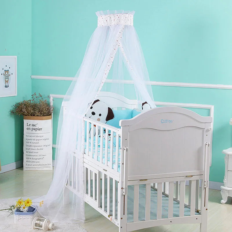 A white foldable mosquito net canopy draped over an infant cot.