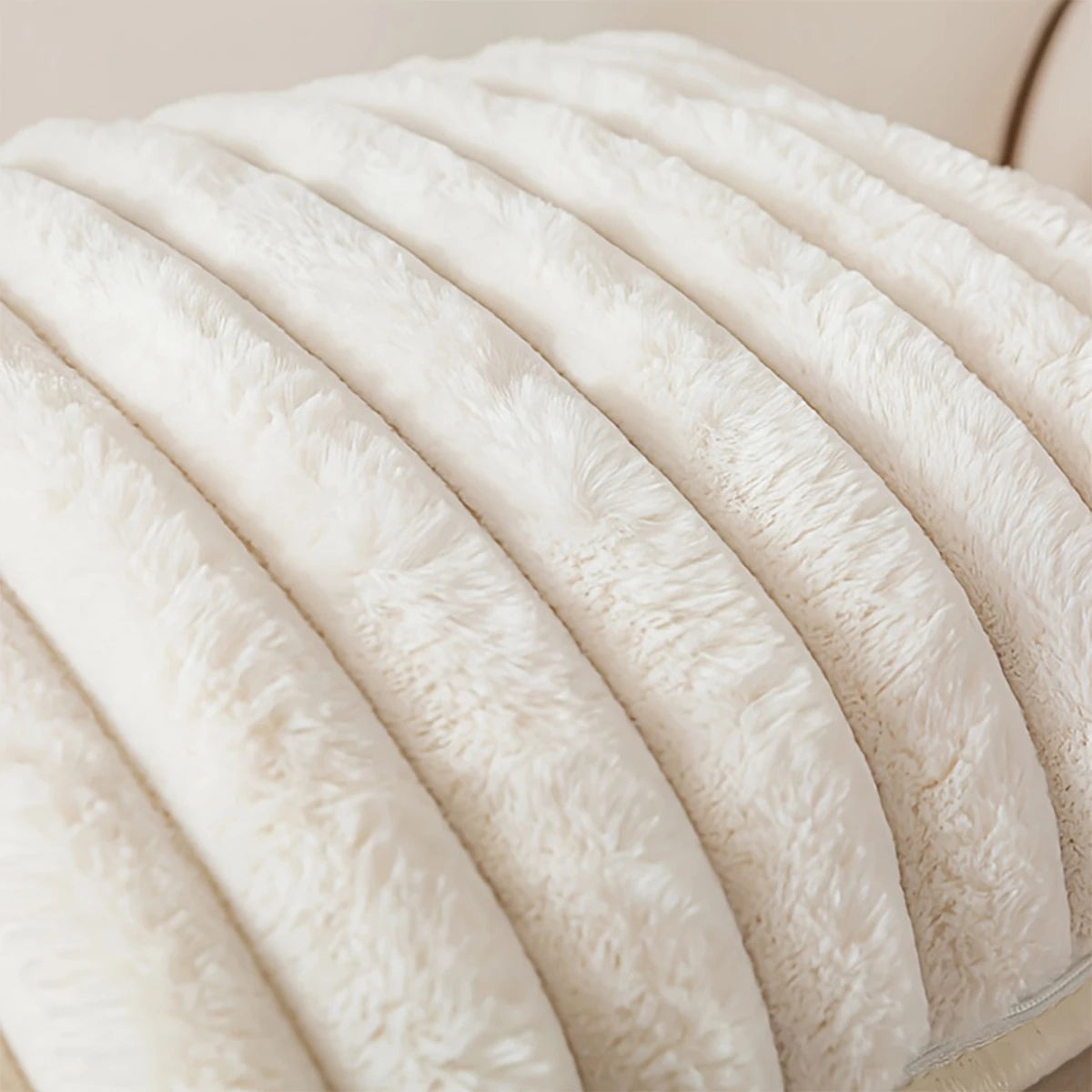 A close-up view of white plush striped decorative pillowcases stacked in a soft, curved arrangement.