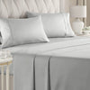 A set of four white luxury microfiber bed sheets with piping and deep pockets on a bed.