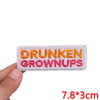 An embroidered patch with the text DRUNKEN GROWNUPS in orange and pink thread.