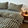 A plaid duvet cover set featuring a green and beige checkered pattern displayed on a bed.
