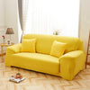 A bright yellow elegant faux silk sofa cover displayed on a light wood floor near a window.