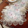 Elegant jacquard lace table runner with floral pattern and gold accents on a dark wood table.