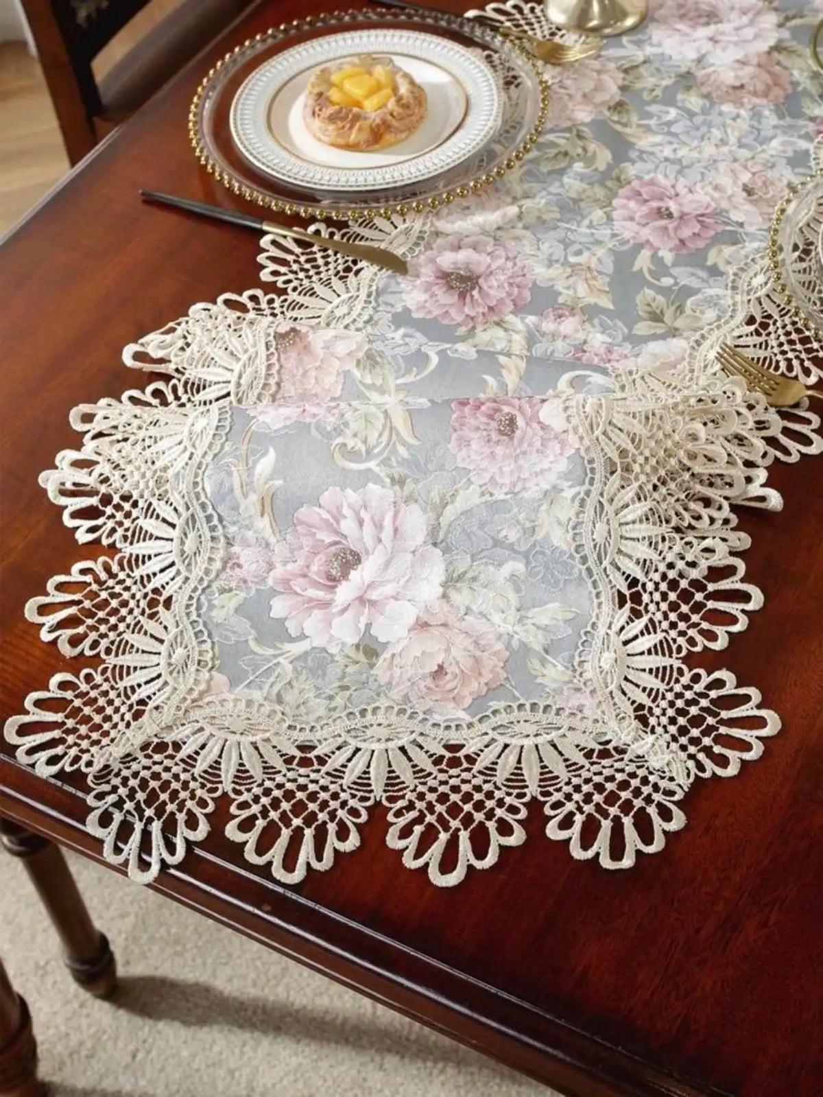 Elegant jacquard lace table runner with floral pattern and gold accents on a dark wood table.