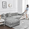 A gray flower print elastic sofa cover protector displayed on a light-colored sofa in a modern living room.