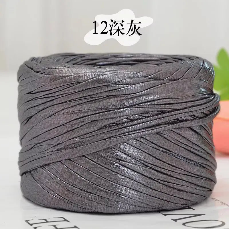 A spool of metallic gray cake yarn with 12 strands coiled for crafting.
