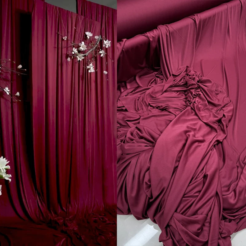 Deep burgundy draping stretch fabric used as a luxurious backdrop or decor.