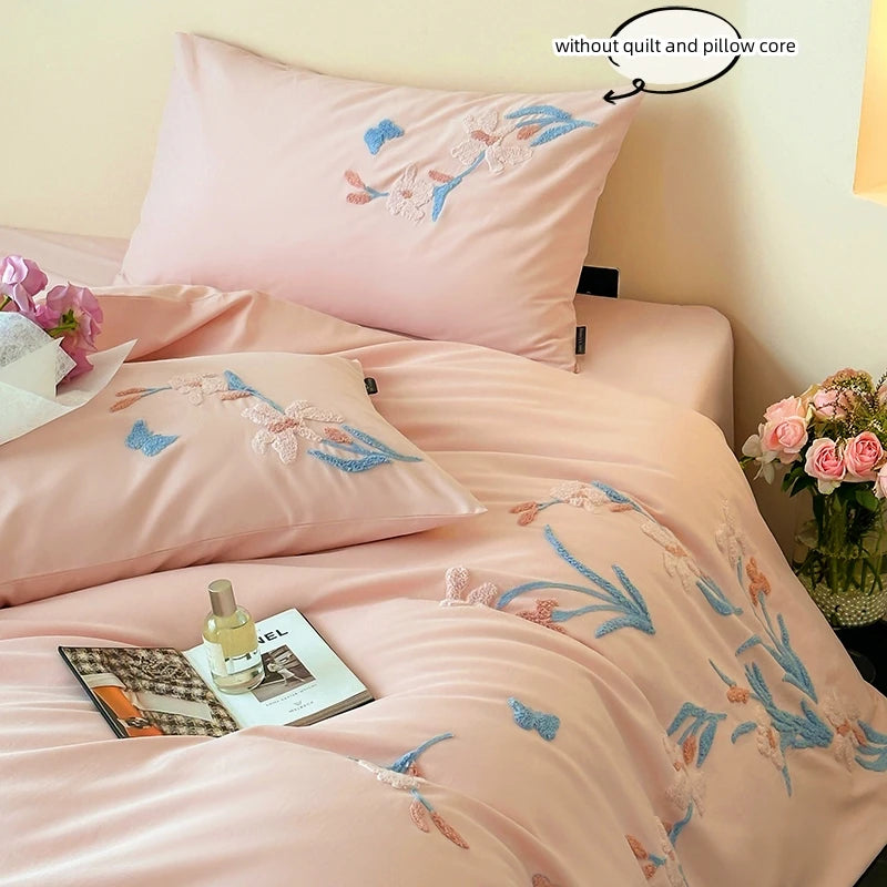 Pink embroidered duvet cover set featuring floral lace trim on a bed.