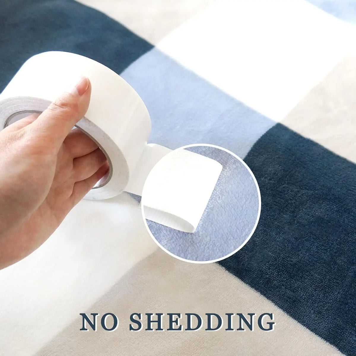 A hand is unwrapping a roll of white adhesive tape on a blue and white striped fabric background.