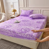 Purple floral fitted sheet set displayed on a bed with white and gold decor.