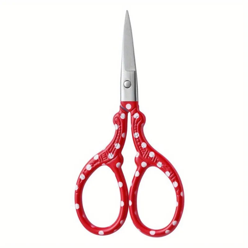 Pair of red and white embroidery scissors with silver blades