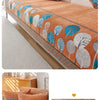 An orange jacquard sofa seat and back cover featuring a pattern of blue, white, and green leaves.