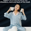 A woman is using a memory foam neck roll pillow for support and relaxation, demonstrating its use on the shoulders, neck, and