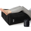 A black inflatable leg elevation wedge pillow is shown supporting a person's legs for pain relief.