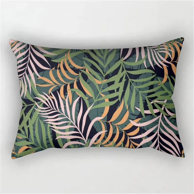 A decorative pillowcase featuring a tropical leaf print in shades of olive green, pink, and orange against a dark background.