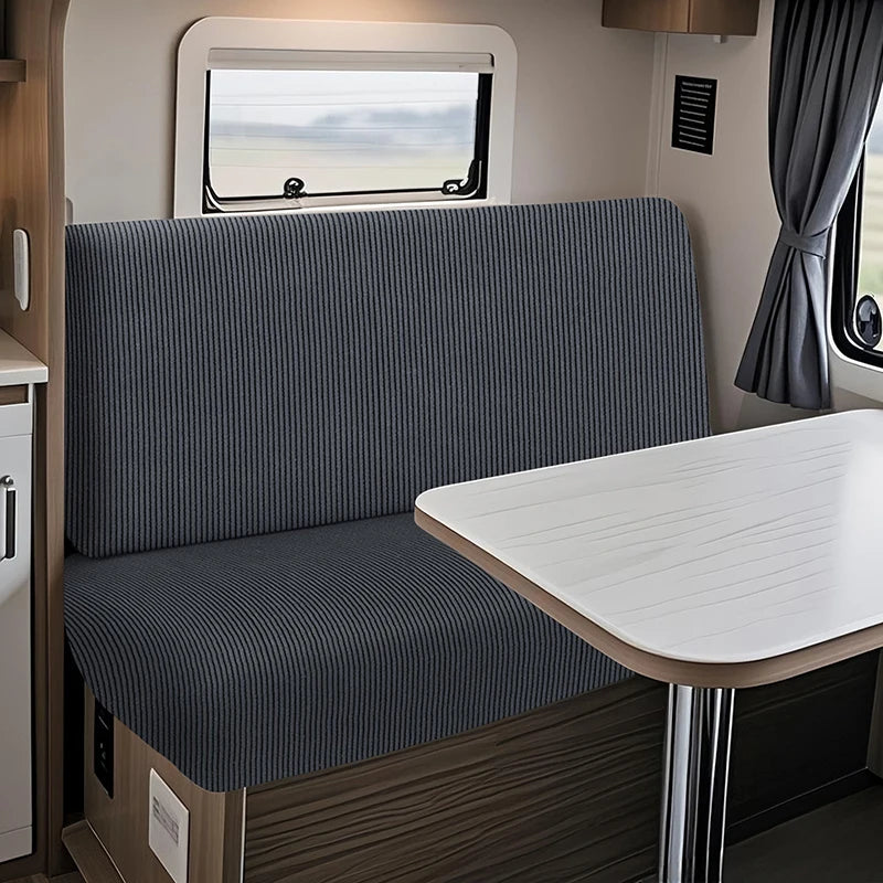 A modern RV dinette featuring a gray striped cushion cover and a white table.