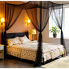 A bedroom featuring a dark wood bed draped with sheer black mosquito net canopy and warm lighting.