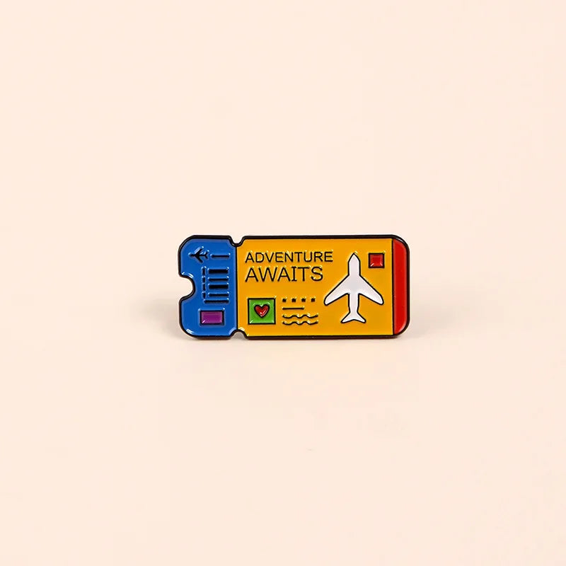 A vintage enamel lapel pin depicting an adventure awaits theme with a plane and heart symbols.