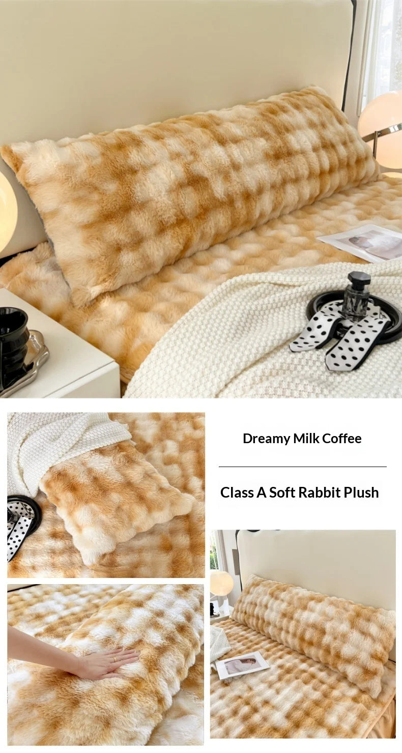 A fluffy, golden-brown rabbit plush long pillowcase displayed on a bed with a white knitted blanket and a mug.