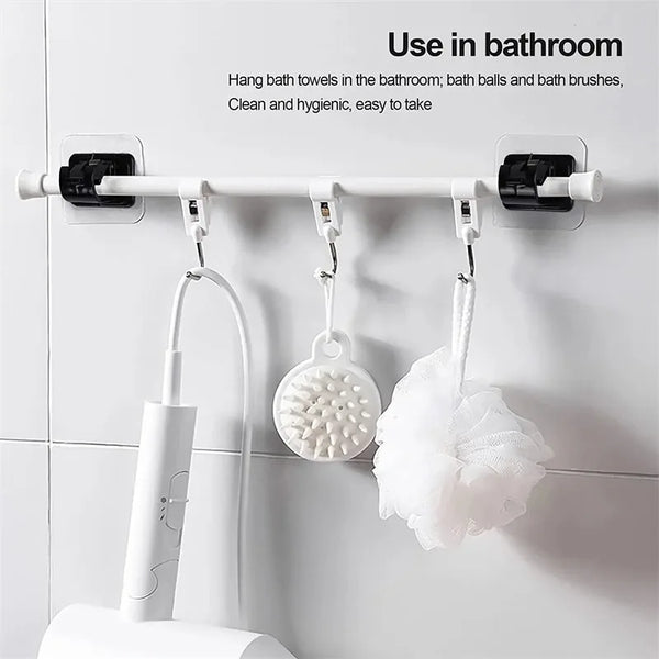 White hanging rod with brackets displaying bath towels, balls, and brushes in a bathroom setting