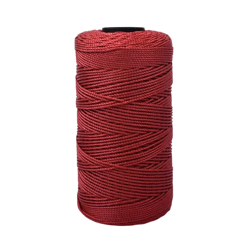 A spool of deep red cotton silk thread for knitting and crafting.