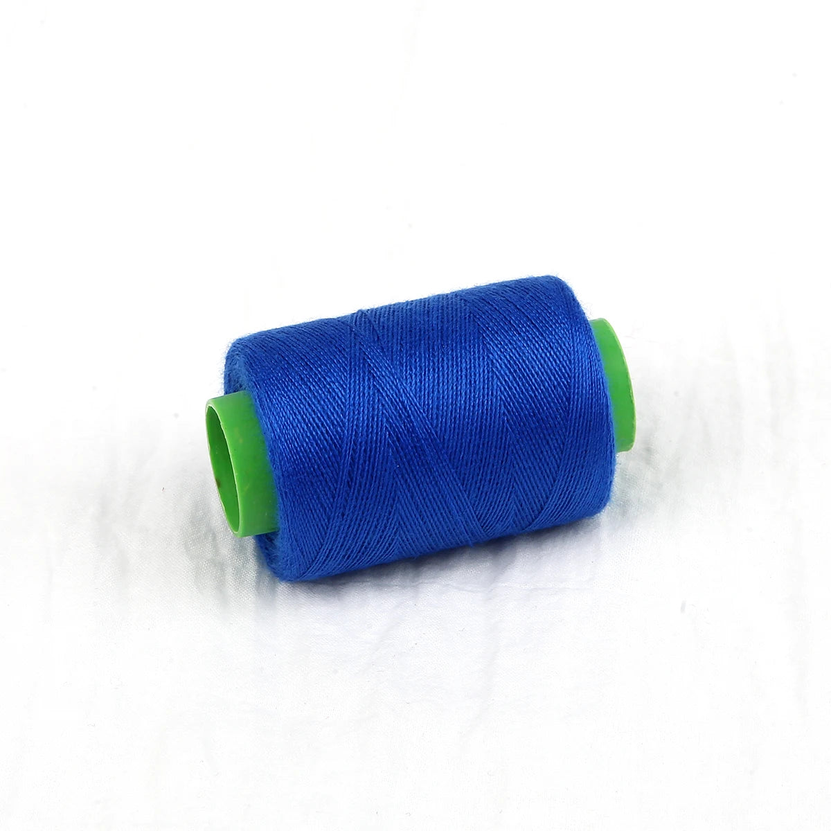 A roll of bright blue handmade sewing threads with green plastic end caps.