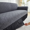 A gray jacquard stretch sofa cover featuring an intricate geometric pattern on a sofa.