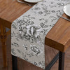 A checkered table runner with a floral pattern is displayed on a wooden table.