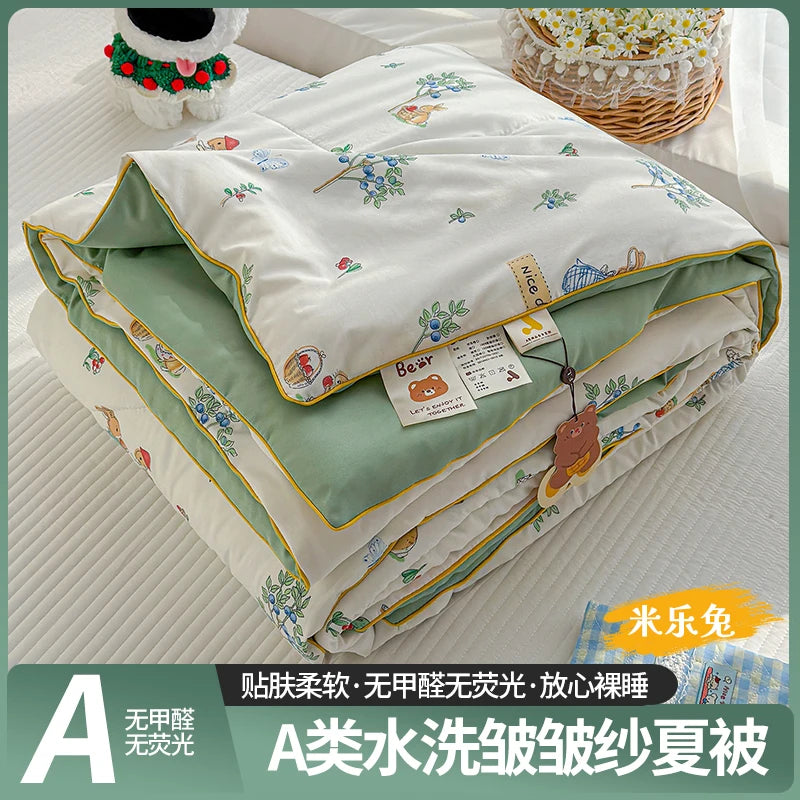 A lightweight summer quilt featuring a cartoon pattern, folded and displayed on a white surface.