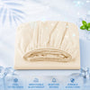 A rolled beige cooling fitted sheet with elastic edges shown on a light surface.