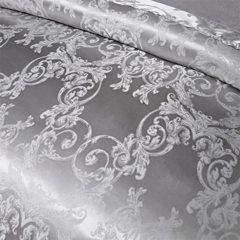A close-up of a silver and white damask fabric used for a luxury duvet cover set.