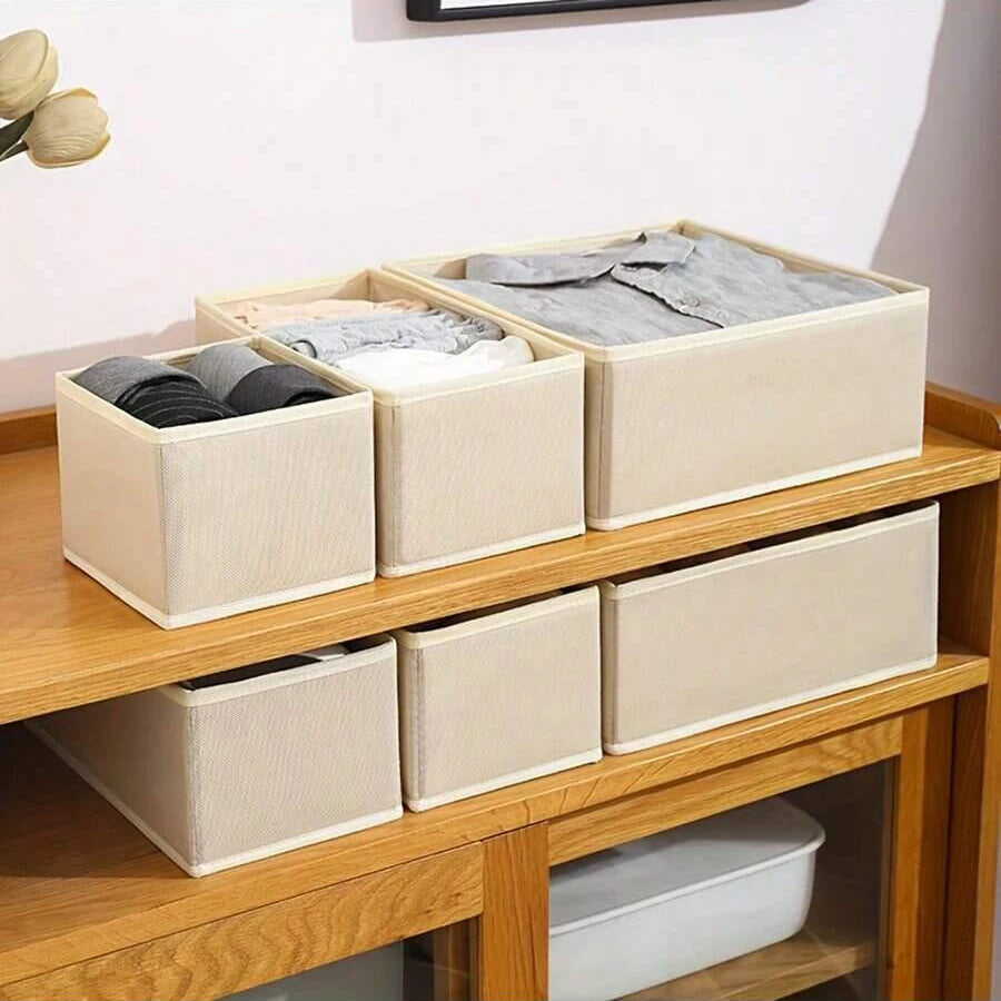 A wooden shelf displaying a beige foldable underwear organizer set with multiple compartments for storing clothing.
