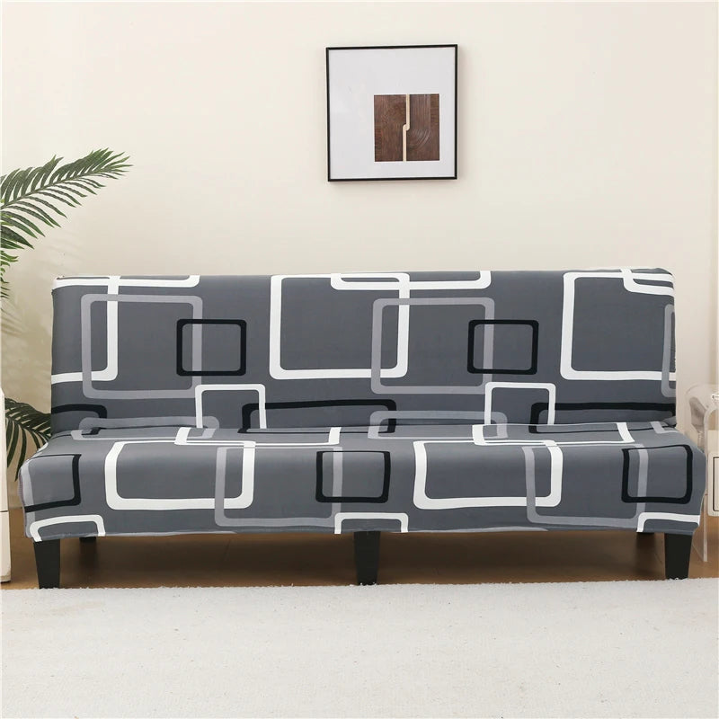 A gray and white geometric print spandex slipcover for a sofa bed placed on a light-colored floor.