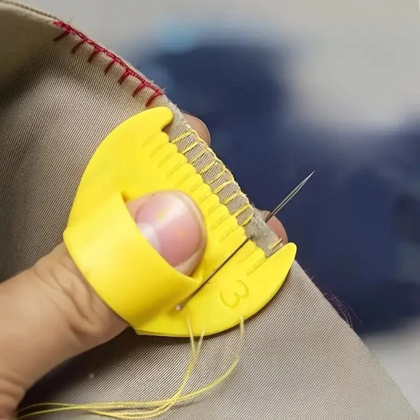 A hand holds a yellow precision stitch tool against a beige fabric, showing the needle tip.