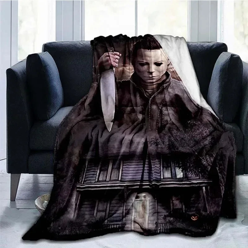 A dark brown horror themed throw blanket featuring a knife design draped over a dark sofa.
