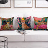 A collection of colorful cushion covers featuring cheetahs and tropical plants displayed on a white sofa.