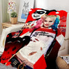 A woman with pink hair and makeup is featured on a red flannel throw blanket design.