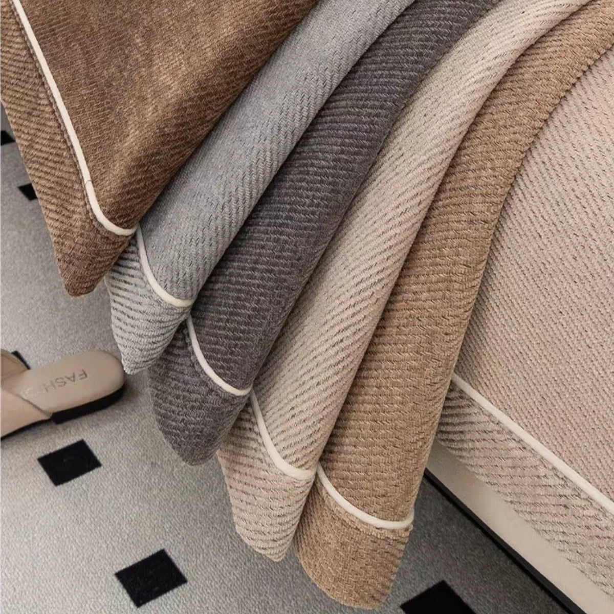 Close-up of a luxurious chenille sofa protector cover in various neutral tones like beige and gray.