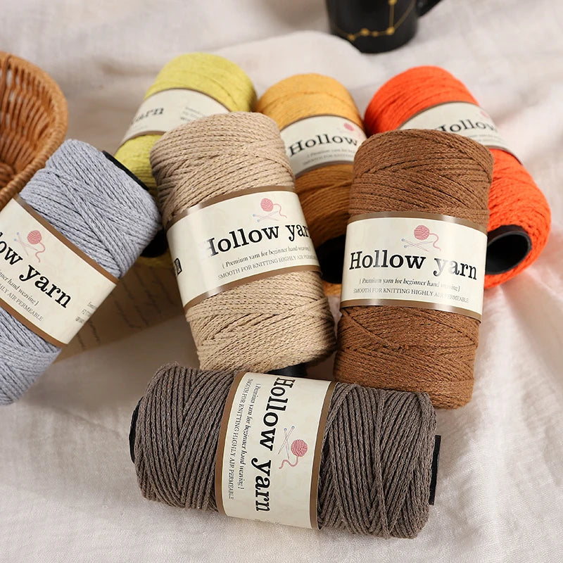 A collection of yellow, orange, and brown wool yarn skeins are displayed on a white cloth.