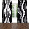 A set of two abstract wavy line curtains in black and white filtering light through a window.
