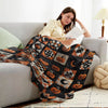 A woman relaxing on a sofa with a vintage patchwork flannel throw blanket featuring Halloween-themed patterns.