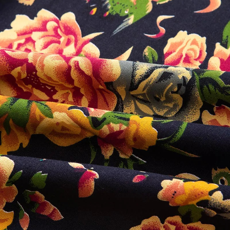 Close-up of bohemian printed linen fabric featuring floral patterns in shades of orange, pink, and yellow on a dark backgroun
