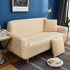 A beige universal stretch sofa and chair slipcover displayed in a modern living room setting.