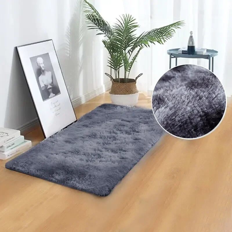 A dark gray thick silk wool area rug placed on a wooden floor next to a potted plant and a decorative tray.