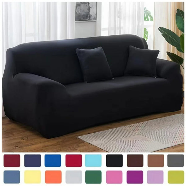 A black stretch sofa cover displayed on a couch in a bright living room setting.