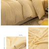 A luxurious beige flannel duvet cover set displayed on a bed, showing the fabric texture and folded product.