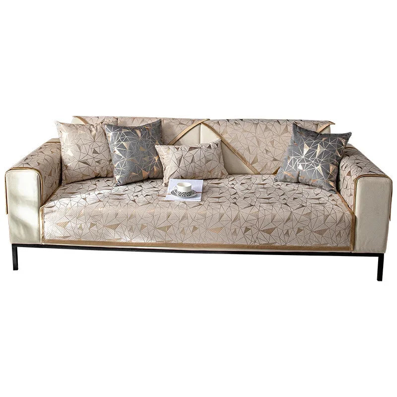 A beige luxury chenille sofa cover featuring geometric patterned throw pillows on a modern sofa.