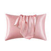 A pink satin silk pillow cover with a draped fabric detail.